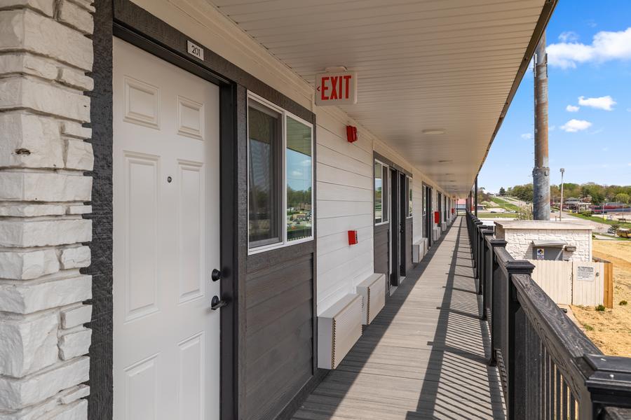 The covered second-floor walkway running the length of the building, with private entry doors.