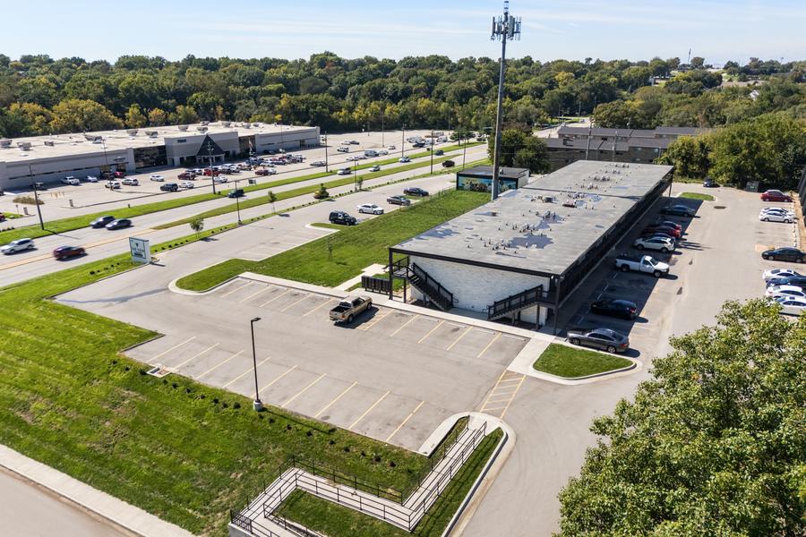 Aerial view showing the property and the shops and parking along the Hickman Road corridor opposite.